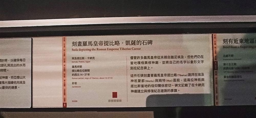 說明牌:刻畫羅馬皇帝提比略.凱薩的石碑(卡納克,西元14–37年,砂岩;記載卡納克神廟的興修事蹟)。
