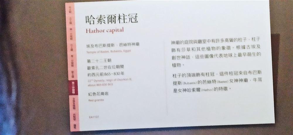 哈索爾柱冠說明牌(第二十二王朝歐索孔二世在位期間,約西元前865–830年,紅色花崗岩,EA1107;出自布巴斯提斯芭絲特神廟)。